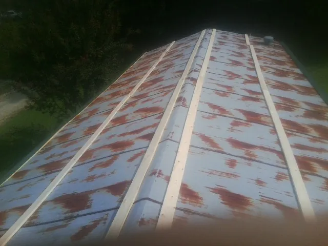 Rusted metal roof panels with new wood purlins before replacement — Storm Damage Roof Repair in Gallatin by Roofing Brothers